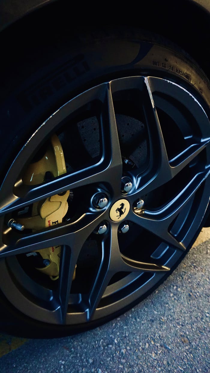 Detailed view of a luxury sports car wheel showcasing sleek design and performance.