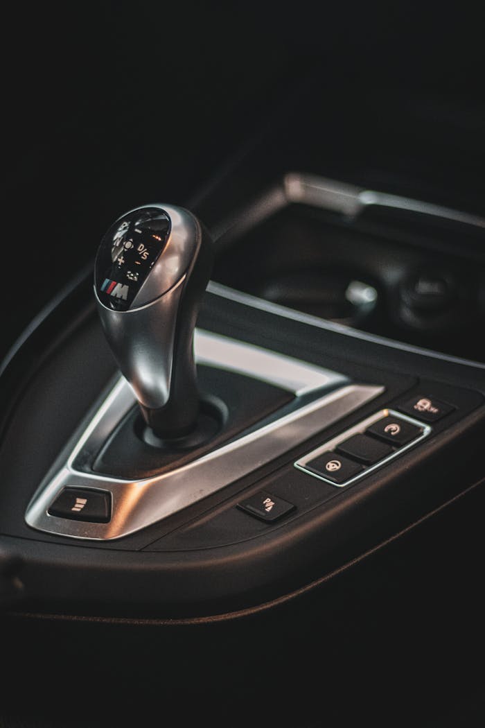 Detailed view of a car gear shift lever with control buttons, highlighting modern automotive design.